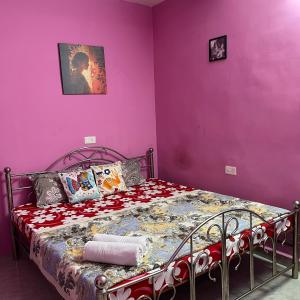 a bedroom with a bed with purple walls at The Human Nest Coliving in Bhubaneshwar