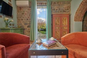 a living room with two chairs and a table with a book at La Gazzara Castell'in Villa in Castelnuovo Berardenga