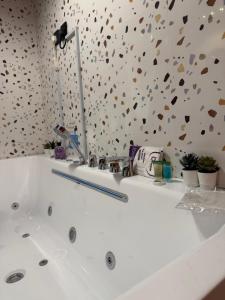 a white bath tub in a bathroom with a flower wall at شقة فاخرة بجاكوزي وبلياردو دخول ذاتي in Hail +17 photos