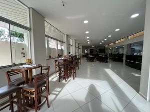 a dining room with tables and chairs in a building at Hotel Santa Clara in Aparecida