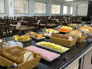 a buffet of food on a table in a classroom at Hotel Santa Clara in Aparecida +11 photos