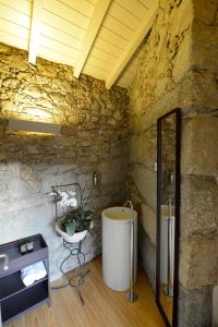 a stone walled bathroom with a tub and a sink at Casa de Docim in Fafe