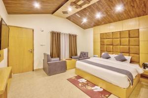 a bedroom with a king sized bed and a chair at Flora Hills Manali in Jagatsukh
