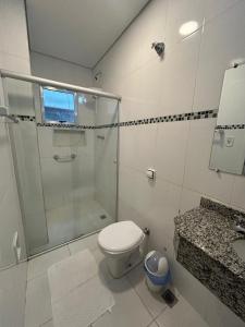 a bathroom with a shower and a toilet and a sink at Hotel Santa Clara in Aparecida