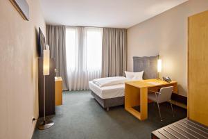 a hotel room with a bed and a desk at Hotel an der Stadtmauer in Schorndorf