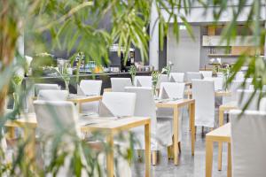 an empty restaurant with tables and white chairs at Hotel an der Stadtmauer in Schorndorf