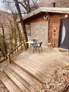 a wooden deck with a table and chairs on it at La Noirie in Saint-Étienne
