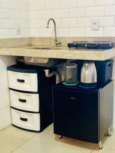 a kitchen with a counter with a sink and some drawers at Flat Beach Park in Aquiraz
