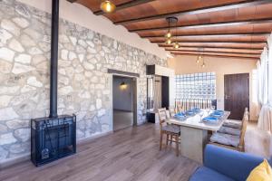 a living room with a stone wall and a fireplace at Hauzify I Mas Blau in L'Ametlla de Mar +16 photos