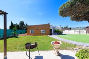 a yard with a building and a basket of flowers at Hauzify I Mas Blau in L'Ametlla de Mar
