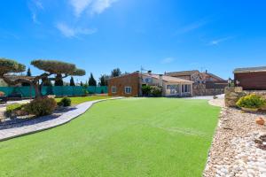 a yard with green grass and a house at Hauzify I Mas Blau in L'Ametlla de Mar