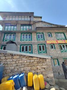 a hotel building with a pile ofools in front of it at Hill-Ten in Namche