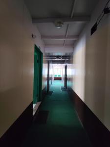 an empty hallway with a green floor and doors at Hill-Ten in Namche