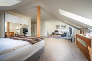 a bedroom with a large bed and a living room at Fischerhaus in Moosburg