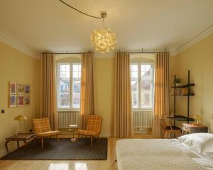 a bedroom with a bed and two windows and a chandelier at Schulze am Markt in Lichtenfels