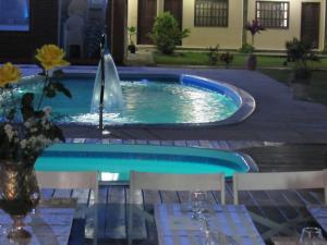 - une piscine avec une fontaine dans la cour dans l'établissement Pousada Tropical, à Prado