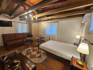 a room with a bed and a table and a couch at Amfitrion Apartments in Gythio