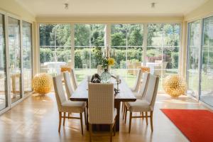 a dining room with a table and chairs and windows at Fischerhaus in Moosburg