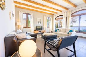 a living room with leather furniture and windows at Sa Torre Voramar in Sa Torre