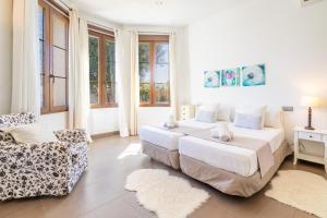 a bedroom with two beds and a chair and windows at Sa Torre Voramar in Sa Torre +34 photos