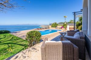 a patio with wicker chairs and a swimming pool at Sa Torre Voramar in Sa Torre