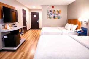 a hotel room with two beds and a flat screen tv at Microtel Inn by Wyndham - Murfreesboro in Murfreesboro +20 photos