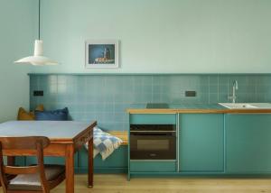 a kitchen with blue tiles and a table and a sink at Schulze am Markt in Lichtenfels +40 photos