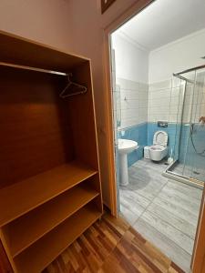 a bathroom with a toilet and a glass shower at Beleris Rooms in Himare +63 photos