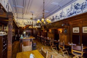a restaurant with a bar and tables and chairs at Hotel Die Port van Cleve in Amsterdam
