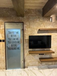 a door with a sign on a wall with a television at rabat apartment in Rabat