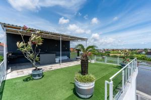 a balcony with a yard with grass and plants at Luxury 5BR Villa with Rooftop BBQ Pool 500M to Beach in Canggu