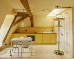 a kitchen with yellow cabinets and a table and chairs at Schulze am Markt in Lichtenfels
