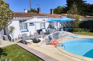 a pool with a slide and chairs and umbrellas at Villa Octavière Gîte Rural in La Chapelle-Achard