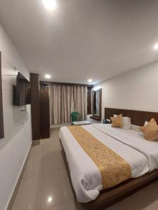 a bedroom with a large bed and a television at Hotel white lion-Near Bhajra Taxi Stand in Gangtok
