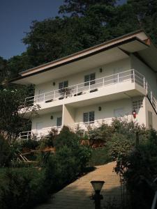 a white building with a balcony on the side of it at Coconut Hill Koh Chang in Khlaung Phai Bae