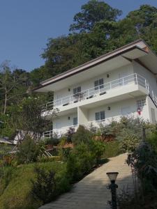 a white building with a walkway in front of it at Coconut Hill Koh Chang in Khlaung Phai Bae +8 photos