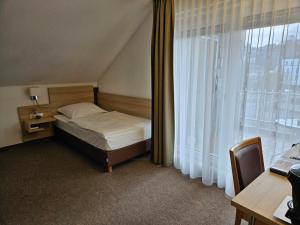 a bedroom with a bed and a large window at Hotel Zum Holländer in Lindlar