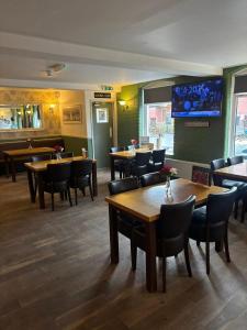 a restaurant with tables and chairs and a tv on the wall at Liberal House Tamworth in Tamworth