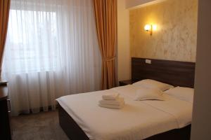 a hotel room with a bed with towels on it at Hotel Premier Botosani in Botoşani