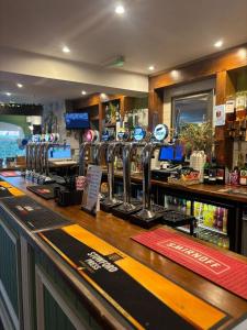 a bar with a counter with a lot of alcohol at Liberal House Tamworth in Tamworth +19 photos
