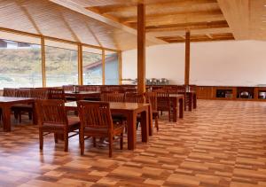 a dining room with wooden tables and chairs at Flora Hills Manali in Jagatsukh