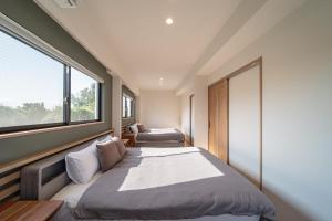 a bedroom with a large bed and a window at LAGUNA OKINAWA Beachfront YAKA in Kin