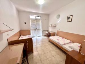 a room with two beds and a table in it at Paxora sobe - Mostar in Mostar