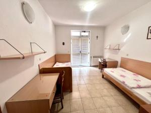 a room with two beds and a cross on the wall at Paxora sobe - Mostar in Mostar +13 photos