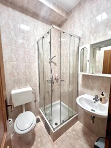 a bathroom with a shower and a toilet and a sink at Paxora sobe - Mostar in Mostar