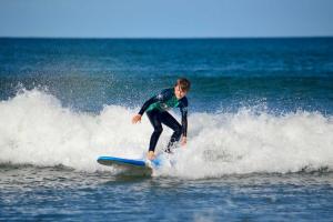 Ein Mann reitet auf einem Surfbrett eine Welle im Meer in der Unterkunft Watersmeet View in Lynmouth