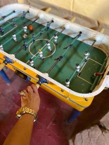 a person holding up a table with a baseball game at Luna Huasi Posada in Maimará