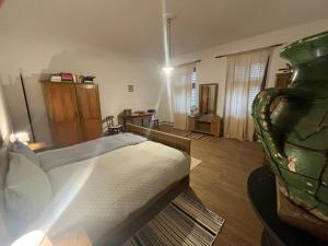 a bedroom with a bed and a room with a desk at Casa Arthur, Transylvanian heritage house in Richişu