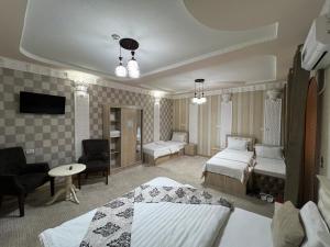 a hotel room with two beds and a living room at Al Samarqandi Hotel in Samarkand +26 photos