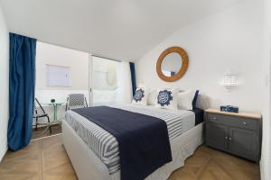 a bedroom with a large bed and a mirror at Casa Margot Old Town Rooftop Walk Promenade in Portimão